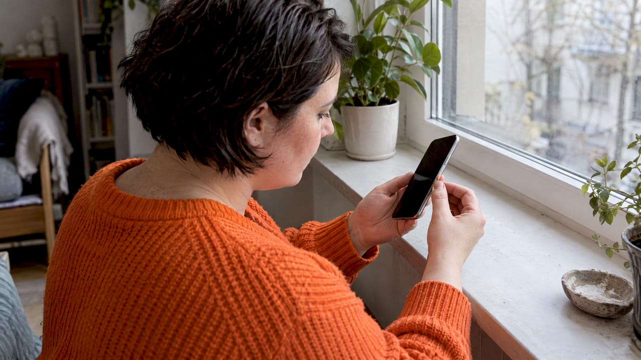 Käuferin untersucht den Zustand eines generalüberholten Smartphones