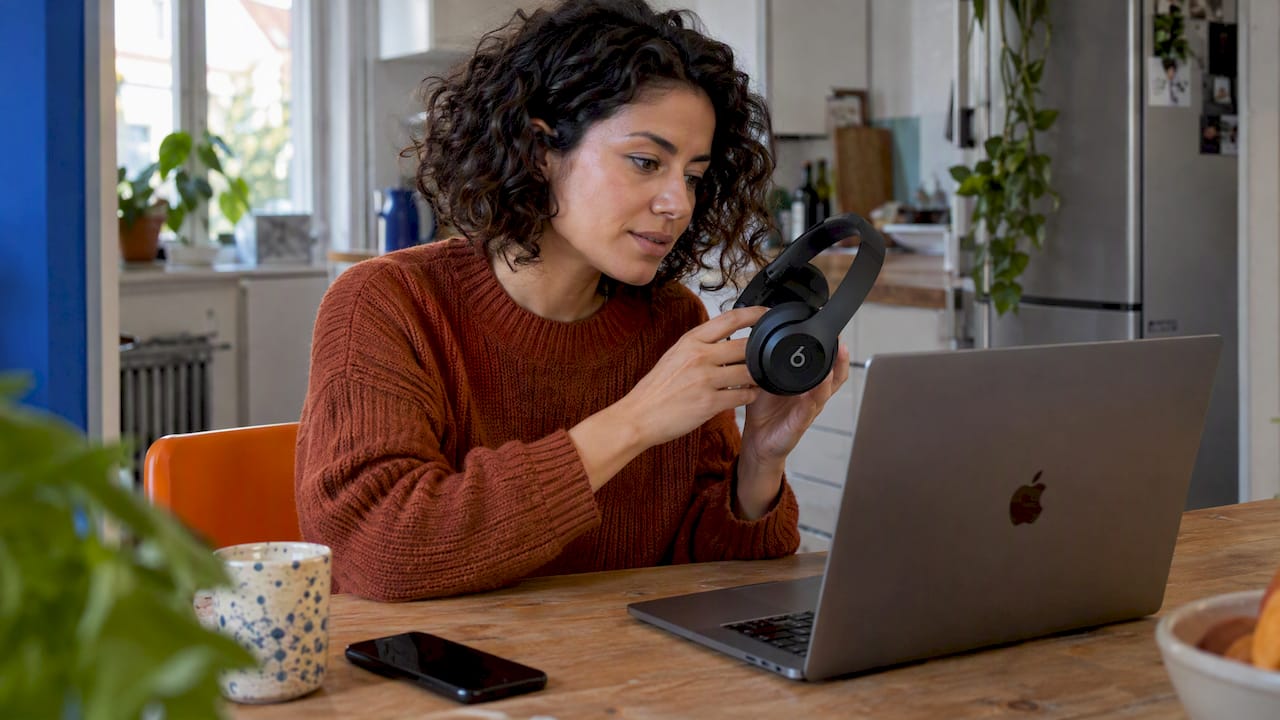Frau überprüft die Beats-Verbindung an ihrem MacBook